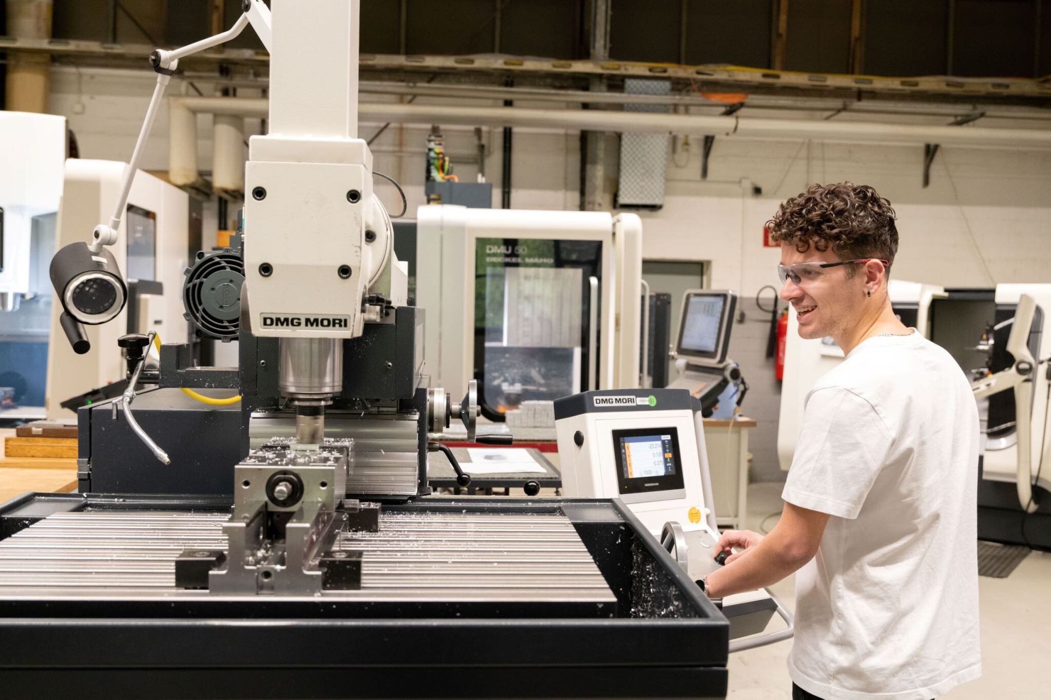 Auszubildender bedient CNC-Fräse
